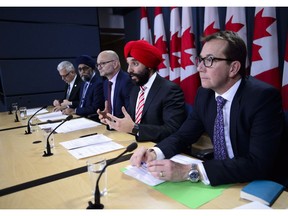 Innovation, Science and Economic Development Minister Navdeep Singh Bains, second from right, joins fellow MP's as the government reacts to the Auditor Generals fall report during a press conference at the National Press Theatre in Ottawa on Tuesday, Nov. 20, 2018.