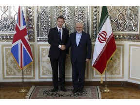 Iranian Foreign Minister Mohammad Javad Zarif, right, and Britain's Foreign Secretary Jeremy Hunt shake hands for the media prior to the start of their meeting in Tehran, Iran, Monday, Nov. 19, 2018.