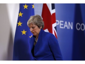 British Prime Minister Theresa May leaves the stand after a media conference in Brussels, Sunday, Nov. 25, 2018. European Union gathered on Sunday to seal an agreement on Britain's departure from the bloc next year, the first time a member country will have left the 28-nation bloc.