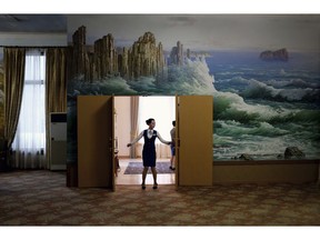 In this Tuesday, Oct. 23, 2018, photo, a staff member closes the doors of a meeting room at the Kumgangsan Hotel at the Mount Kumgang resort area which was once a popular destination for South Korean tourists, in North Korea. A decade after the North-South experiment in tourism cooperation in Kumgang ended in bitter failure following the fatal shooting of a South Korean tourist in 2008, North Korean leader Kim Jong Un and South Korean President Moon Jae-in want to give it another try amid opposition from Washington.
