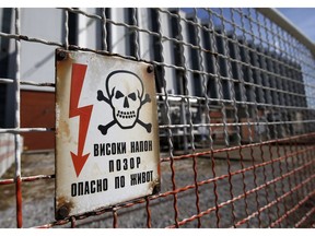 In this photo taken Wednesday, Oct. 3, 2018, a warning sign of existing high voltage at the fence of Serbia's main coal-fired power station near Kostolac, Serbia.