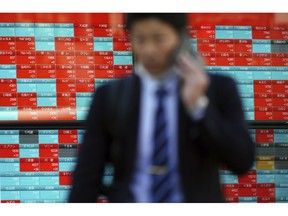 A man walks past an electronic stock board showing Japan's Nikkei 225 index at a securities firm in Tokyo Thursday, Nov. 1, 2018. Stocks climbed for the second day in a row Wednesday at the end of a brutal month for the global market.