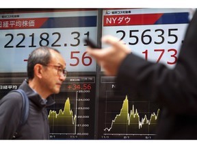 Men walk past an electronic stock board showing Japan's Nikkei 225 index at a securities firm in Tokyo Wednesday, Nov. 7, 2018. Asian shares were mostly higher Wednesday as investors awaited results from the U.S. midterm elections, which could have an impact on the global economy and trade.