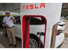 In this June 22, 2018, photo, Shan Junhua chats about privacy near his white Tesla while charging it in Shanghai. When Shan bought his white Tesla Model X, he knew it was a fast, beautiful car. What he didn't know is that Tesla constantly sends information about the precise location of his car to the Chinese government. Automakers selling electric vehicles in China send a constant feed of information about the location of cars to the government, potentially adding to the rich kit of surveillance tools available to the regime as President Xi Jinping steps up the use of technology to track Chinese citizens.