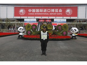 In this Nov. 5, 2018, photo, a security guard stands at the entrance to the China International Import Expo in Shanghai. Visitors to the vast trade fair meant to rebrand China as a welcoming import market could sip Moroccan wine, ogle Italian yachts and watch a Japanese industrial robot play ping-pong.