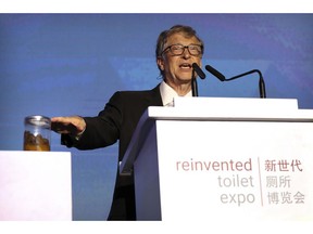 Bill Gates, former Microsoft CEO and co-founder of the Bill and Melinda Gates Foundation, gestures to a jar of human feces as he speaks at the Reinvented Toilet Expo in Beijing, Tuesday, Nov. 6, 2018. With a jar of human feces on a podium next to him, billionaire philanthropist Bill Gates has kicked off a "Reinvented Toilet" Expo in China. Gates said Tuesday that the technologies on display at the three-day expo in Beijing represent the most significant advances in sanitation in nearly 200 years.