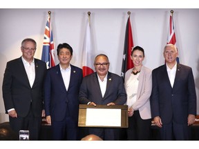 From left, Australian Prime Minister Scott Morrison, Japanese Prime Minister Shinzo Abe, Papua New Guinea's Prime Minister Peter O'Neill, New Zealand's Prime Minister Jacinda Ardern and U.S. Vice President Mike Pence pose for a group photo after signing the Papua New Guinea Electrification Partnership at APEC Haus in Port Moresby, Papua New Guinea, Sunday, Nov. 18, 2018.