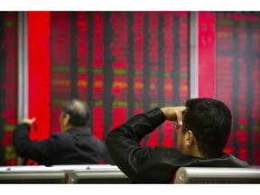 In this Oct. 31, 2018, photo, Chinese investors monitor stock prices at a brokerage house in Beijing. China's government is trying to dispel stock market gloom and talk prices back up with promises of tax cuts and a media campaign led by its economic czar.