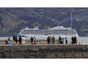 In this Oct. 2, 2018 photo, tourists from a cruise ship walk along the wharf at Akaroa in the South Island of New Zealand. With concern rising about the impact of tourism on the environment, New Zealand on Thursday, Nov. 1, 2018, launched a new campaign to try to get visitors to dispose of their litter in bins and otherwise take care of the country.