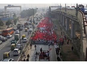 Farmers, workers and agricultural laborers wave red communist flags as they arrive in the Indian capital for a two day's protest in New Delhi, India, Thursday, Nov.29, 2018. The Indian farmers have been protesting demanding redressal of various issues in the agriculture sector.