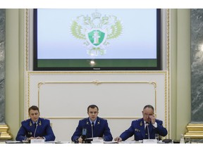 From left, an aide to the Russian Prosecutor General Mikhail Alexandrov, Russian Prosecutor General spokesman Alexander Kurennoi, and an aide to the Russian Prosecutor General Nikolai Atmoniev attend a news conference in Moscow, Russia, Monday, Nov. 19, 2018. Russian prosecutors on Monday announced new charges against Bill Browder, accusing him of forming a criminal group to embezzle funds in Russia. They also said they suspect Magnitsky's death in prison was a poisoning and said they have a "theory" Browder is behind the poisoning.