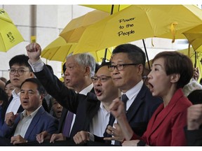 Occupy Central leaders, from right, Tanya Chan, Chan Kin Man, Benny Tai, Chu Yiu Ming and Lee Wing Tat shout slogans before entering a court in Hong Kong, Monday, Nov. 19, 2018. Nine leaders of the 2014 Hong Kong pro-democracy movement stand trial. The co-founders of the "Occupy Central" campaign - legal Prof. Benny Tai Yiu-Ting, sociology professor Chan Kin-man and retired pastor Chu Yiu-ming - are facing charges related to the planning and implementation of the campaign which became part of the large-scale pro-democracy Umbrella Movement protests which were carried out 79 days between September and December 2014.