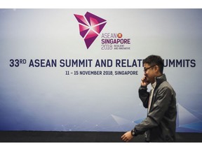A man walks past an event banner at the Suntec Convention Centre during the 33rd ASEAN summit in Singapore, Monday, Nov. 12, 2018.