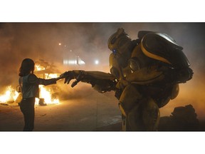This image released by Paramount Pictures shows Hailee Steinfeld as Charlie and Bumblebee in a scene from "Bumblebee." (Paramount Pictures via AP)