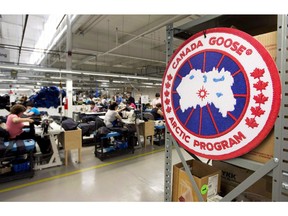 Employees work with Canada Goose jackets at the Canada Goose factory in Toronto on Thursday, April 2, 2015. Canada Goose Inc. says the opening of its Beijing store is delayed slightly for construction.