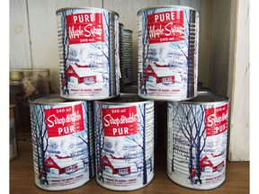 Maple syrup cans are seen at a sugar shack in Oka, Que., on February 10, 2017. Statistics Canada says maple syrup production fell by 21.7 per cent to 44.5 million litres in 2018, the lowest level in three years. Production was down in every maple-producing province except Nova Scotia and Ontario, which saw output rise 9.4 per cent to 2.1 million litres, the most since 2011.