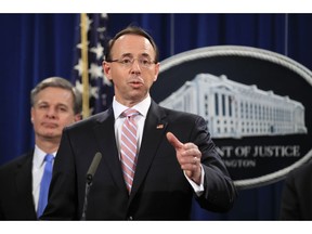 Deputy Attorney General Rod Rosenstein with FBI Director Christopher Wray, speaks during a news conference at the Department of Justice in Washington, Thursday, Dec. 20, 2018. The Justice Department is charging two Chinese citizens with carrying out an extensive hacking campaign to steal data from U.S. companies. An indictment was unsealed Thursday against Zhu Hua and Zhang Shillong. Court papers filed in Manhattan federal court allege the hackers were able to breach the computers of more than 45 entities in 12 states.