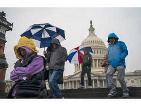 Tourists arrive to visit the U.S. Capitol on a rainy morning in Washington, Friday, Dec. 28, 2018, during a partial government shutdown. The partial government shutdown will almost certainly be handed off to a divided government to solve in the new year, as both parties traded blame Friday and President Donald Trump sought to raise the stakes in the weeklong impasse.