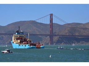 File - In this Sept. 8, 2018 file photo, a ship tows The Ocean Cleanup's first buoyant trash-collecting device toward the Golden Gate Bridge in San Francisco en route to the Pacific Ocean. The trash collection device deployed to corral plastic litter floating between California and Hawaii in an attempt to clean up the world's largest garbage patch is not collecting any trash. But Boyan Slat, who launched the Pacific Ocean cleanup project, told The Associated Press in an interview Monday, Dec. 17, 2018, he is confident the 2,000-foot (600-meter) long floating boom will be fixed.