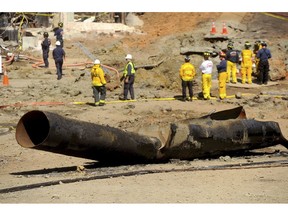 FILE - In this Sept. 11, 2010, file photo, a natural gas line lies broken on a San Bruno, Calif., road after a massive explosion. The California Public Utilities Commission said Friday, Dec. 14, 2018, that an investigation by its staff found Pacific Gas & Electric Co. lacked enough employees to fulfill requests to find and mark natural gas pipelines. A U.S. judge fined the utility $3 million after it was convicted of six felony charges for failing to properly maintain a natural gas pipeline that exploded south of San Francisco in 2010, killing eight people.