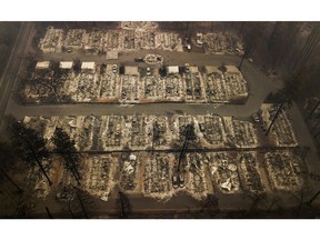 FILE - This Thursday, Nov. 15, 2018, file aerial photo shows the remains of residences leveled by the wildfire in Paradise, Calif. California's attorney general has told a federal judge it's possible Pacific Gas & Electric Co. could face charges up to murder if investigators find reckless operation of power equipment caused any deadly wildfires in the past two years. The Sacramento Bee reports the brief is purely advisory and any criminal charges would most likely be filed by county district attorneys.
