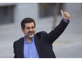 FILE- In this Oct. 16, 2017 file photo, Jordi Sanchez, president of the Catalan National Assembly, gestures to supporters on arrival at the national court in Madrid.  It is announced Thursday Dec. 20, 2018, that four jailed Catalan separatist leaders, including Sanchez, are abandoning their hunger strike more than two weeks after starting it because they consider that their protest has achieved its goals.