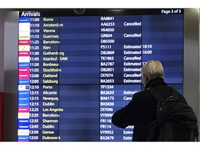 A passenger checks an arrivals board at Gatwick Airport in England, Friday, Dec. 21, 2018. Flights resumed at London's Gatwick Airport on Friday morning after drones sparked the shutdown of the airfield for more than 24 hours, leaving tens of thousands of passengers stranded or delayed during the busy holiday season.