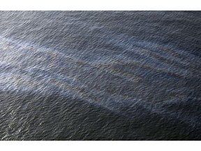 FILE - This March 31, 2015, file photo shows an oil sheen drifting from the site of the former Taylor Energy oil rig in the Gulf of Mexico, off the coast of Louisiana.  A federal lawsuit that Taylor Energy Co. filed Thursday, Dec. 20, 2018,  in New Orleans asks the court to throw out Coast Guard Capt. Kristi Luttrell's Oct. 23 administrative order. The suit claims the Coast Guard's actions ignored "well-verified scientific conclusions" and were taken in response to "adverse publicity."