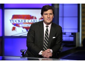 FILE - In this March 2, 2017, file photo, Tucker Carlson, host of "Tucker Carlson Tonight," poses for photos in a Fox News Channel studio in New York. Some advertisers say they are leaving conservative host Carlson's show following his remarks referring to immigrants as "the world's poor." It's the latest example of sponsors leaving a Fox News Channel show after controversy, but experts say the flap is likely to blow over. So far, the biggest advertisers are sticking with him and his show, "Tucker Carlson Tonight."