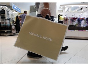 FILE- In this Nov. 23, 2018, file photo a shopper walks through Dolphin Mall while shopping on Black Friday in Miami. On Friday, Dec. 14, the Commerce Department releases U.S. retail sales data for November.