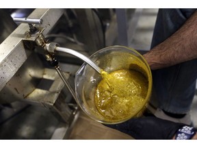 FILE - In this April 24, 2018, file photo, the first rendering from hemp plants extracted from a super critical CO2 extraction device on it's way to becoming fully refined CBD oil spurts into a large beaker at New Earth Biosciences in Salem, Ore. The hemp industry still has work ahead to win legal status for hemp-derived cannabidiol, or CBD oil. The head of the Food and Drug Administration says adding CBD to food or dietary supplements is still illegal. President Donald Trump signed a farm bill this week designating hemp as an agricultural crop, but FDA Commissioner Scott Gottlieb issued a statement saying CBD is a drug ingredient and therefore illegal to add to food or supplements without approval from his agency.