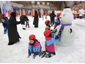 FILE - In this March 9, 2018 file photo, children play by snow at the "Snow City" in the Othaim Mall, in Riyadh, Saudi Arabia. King Salman has extended monthly allowances for government employees, military personnel, pensioners, social security recipients and students into next year. The announcement, carried by the Saudi Press Agency on Tuesday, Dec. 18, 2018, comes on the same day the kingdom's 2019 budget is scheduled to be unveiled.
