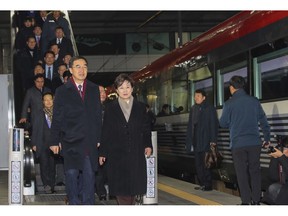 South Korean Unification Minister Cho Myoung-gyon, bottom left, and officials arrive to board a train to leave for the North Korea at the Seoul Railway Station in Seoul, South Korea, Wednesday, Dec. 26, 2018. South Korean officials have traveled to North Korea by train to attend a groundbreaking ceremony for an aspirational project to modernize North Korean railways and roads and connect them with the South.