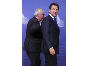 European Commission President Jean-Claude Juncker, left, walks with Italian Prime Minister Giuseppe Conte prior to a meeting at EU headquarters in Brussels, Wednesday, Dec. 12, 2018.