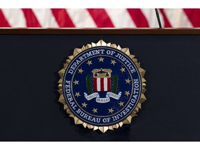 FILE - In this June 14, 2018, file photo, the FBI seal is seen before a news conference at FBI headquarters in Washington. The FBI is grappling with a seemingly endless cycle of money laundering schemes that law enforcement officials say they're scrambling to slow through a combination of prosecution and public awareness. Beyond the run-of-the-mill plots, officials say, is a particularly concerning trend involving "money mules." These are people who, unwittingly or not, use their own bank accounts to move money for criminals for purposes they think are legitimate or even noble.