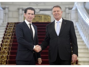 Austrian Chancellor Sebastian Kurz, left, shakes hands with Romanian President Klaus Iohannis at the Cotroceni presidential palace in Bucharest, Romania, Friday, Dec. 21, 2018.
