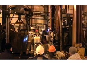 In this video grab provided by RU-RTR Russian television via AP television, Russian rescue team wait for a elevator to go down into the mine potash mine in Solikamsk, the Perm region near the Ural Mountains, Russia, Saturday, Dec. 22, 2018. Russian emergency teams struggled Saturday to reach nine construction workers trapped inside a burning potash mine in the Perm region near the Ural Mountains. (RU-RTR Russian Television via AP)