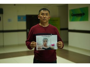 In this photo taken Dec. 7, 2018, Mussa Imamadiuly, a truck driver, stands with a picture of his wife's little brother for a photo outside the office of an advocacy group for ethnic Kazakhs born in China in Almaty, Kazakhstan on Imamadiuly says shortly after his marriage, his new wife's little brother was arrested and taken to an internment camp. Last month, they heard through relatives still in China that police had notified them that his wife's little brother was about to be transferred to a factory.