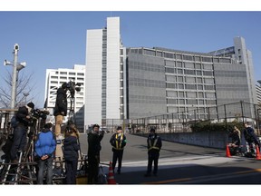 Media persons stand by outside Tokyo Detention Center, where former Nissan chairman Carlos Ghosn and former another executive Greg Kelly are being detained, in Tokyo Friday, Dec. 21, 2018. Japanese media say prosecutors have added a new allegation of breach of trust against Ghosn, dashing his hopes for release on bail.
