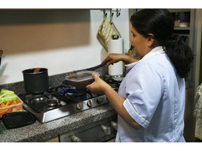 In this Dec. 14, 2018 photo, domestic worker Rocio Campos, 55, prepares lunch for her employer, in Mexico City. The Supreme Court ruled on Dec. 5 that Mexico's more than 2 million domestic workers should be enrolled in the social security system, offering them greater rights as well as access to the public health system and free, government-run daycare.