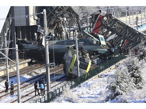 Members of rescue services work at the scene of a train accident in Ankara, Turkey, Thursday, Dec. 13, 2018. A high-speed train hit a railway engine and crashed into a pedestrian overpass at a station in the Turkish capital Ankara on Thursday, killing more than 5 people and injuring more than 40 others, officials and news reports said.