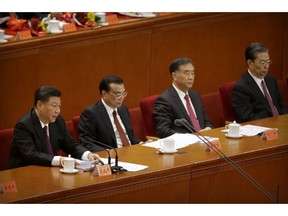 Chinese President Xi Jinping, left, speaks during a conference to commemorate the 40th anniversary of China's Reform and Opening Up policy at the Great Hall of the People in Beijing, Tuesday, Dec. 18, 2018.