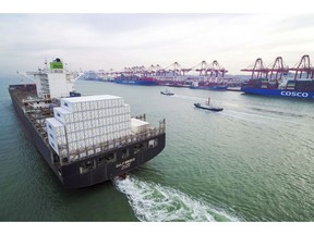 In this Dec. 8, 2018, photo, a container ship sails past a port in Qingdao in eastern China's Shandong province. News reports, Friday, Dec. 21, 2018, say Chinese leaders are promising tax cuts and more help to entrepreneurs in their 2019 economic plan amid official efforts to reverse a deepening slowdown in growth. (Chinatopix via AP)