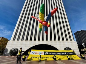 Amnesty International activists hold a giant dragonfly-shaped balloon with a banner reading "Google, do not censor in China, no to the Dragonfly project" during a protest outside Google's Madrid headquarters on Nov. 27, 2018 as part of a campaign calling on Google to cancel its plan to launch a censored search engine in China.