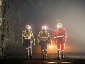 Acacia workers walk through a dust-shrouded mine.