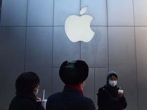People walk past an Apple store in Beijing on December 11, 2018.