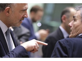 European Commissioner for Economic and Financial Affairs Pierre Moscovici, left, speaks with Greek Finance Minister Euclid Tsakalotos during a round table meeting of eurogroup finance ministers at the Europa building in Brussels, Monday, Dec. 3, 2018. Eurozone finance ministers meet in Brussels on Monday to discuss the standoff between Italy and the group over its spending proposals for the 2019 budget.