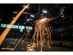 Fabricator Mike Caldarino uses a grinder on a steel stairs being manufactured for a high school in Redmond, Wash., at George Third & Son Steel Fabricators and Erectors, in Burnaby, B.C., on March 29, 2018.