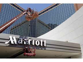 In this Tuesday, April 30, 2013, file photo, a man works on a new Marriott sign in front of the former Peabody Hotel in Little Rock, Ark. Canadians have started receiving emails from Marriott International, informing them of a recent breach of personal data held by their Starwood hotel properties.