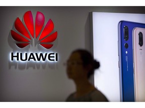 A shopper walks past a Huawei store at a shopping mall in Beijing Wednesday, July 4, 2018. The Justice Department says the chief financial officer of China's Huawei Technologies, who is sought for extradition by the United States, has been arrested in Vancouver.